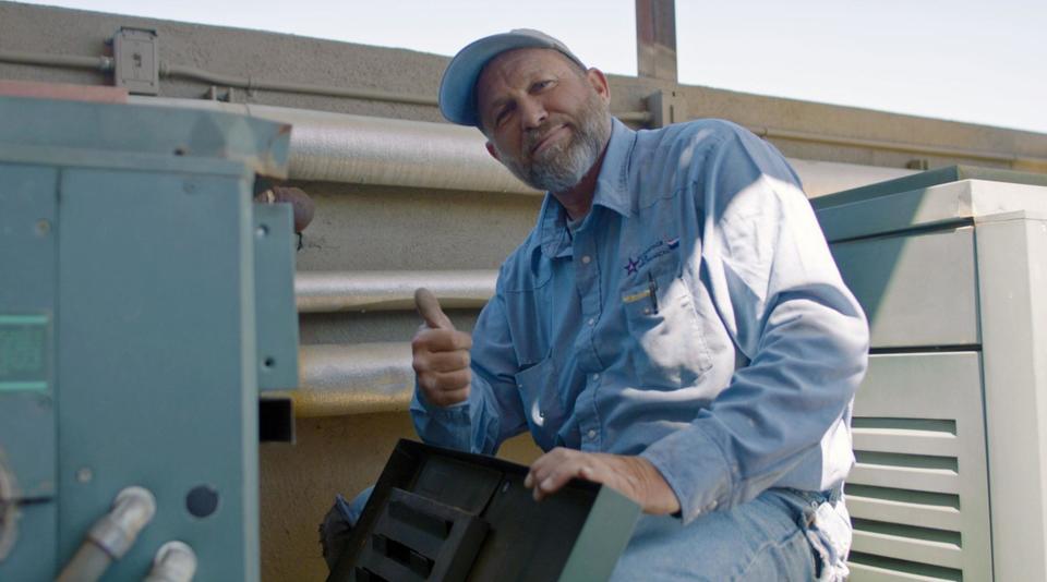 An Advantage Air Mechanical technician wearing a branded shirt giving a thumbs up to the camera