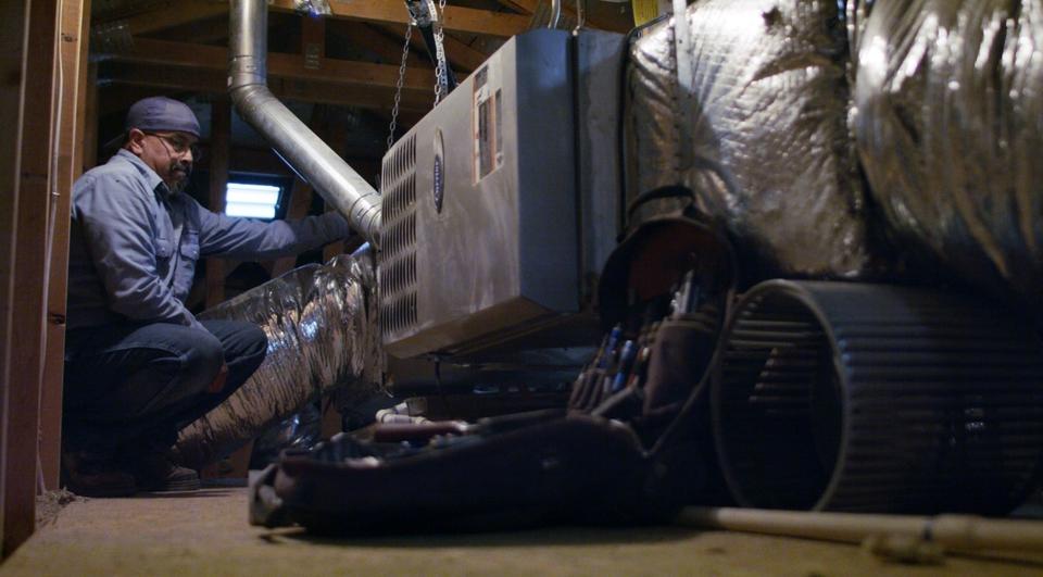 Advantage Air Mechanical HVAC technician in blue button-up shirt working on a furnace system