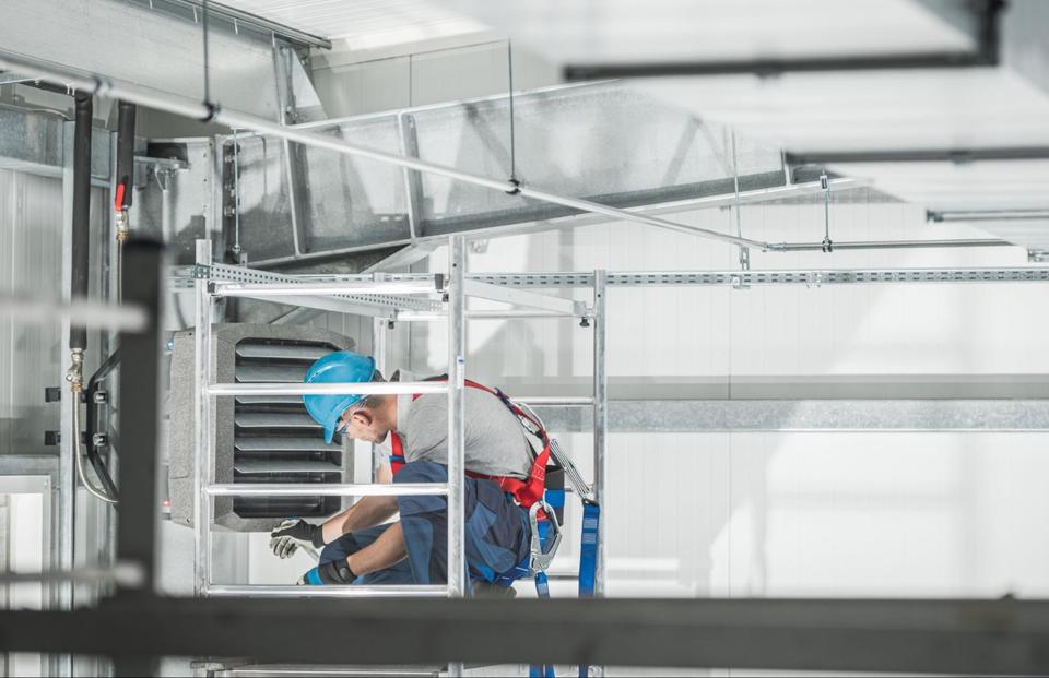 HVAC technician working on a commercial heating and ductwork system