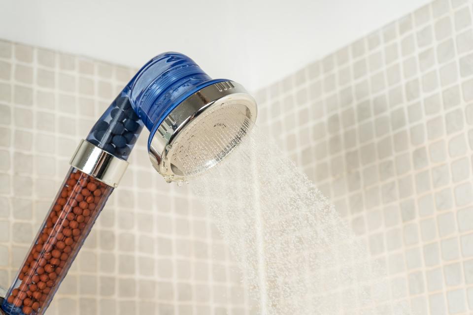 Picture of a shower head in a Tucson home bathroom spraying water after having hard water cleaned