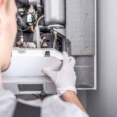 Professional HVAC technician performing a maintenance check up on a heater before winter starts