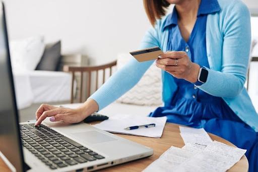 Woman with credit card using laptop