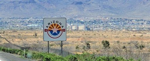 Arizona state sign on side of road overlooking a city